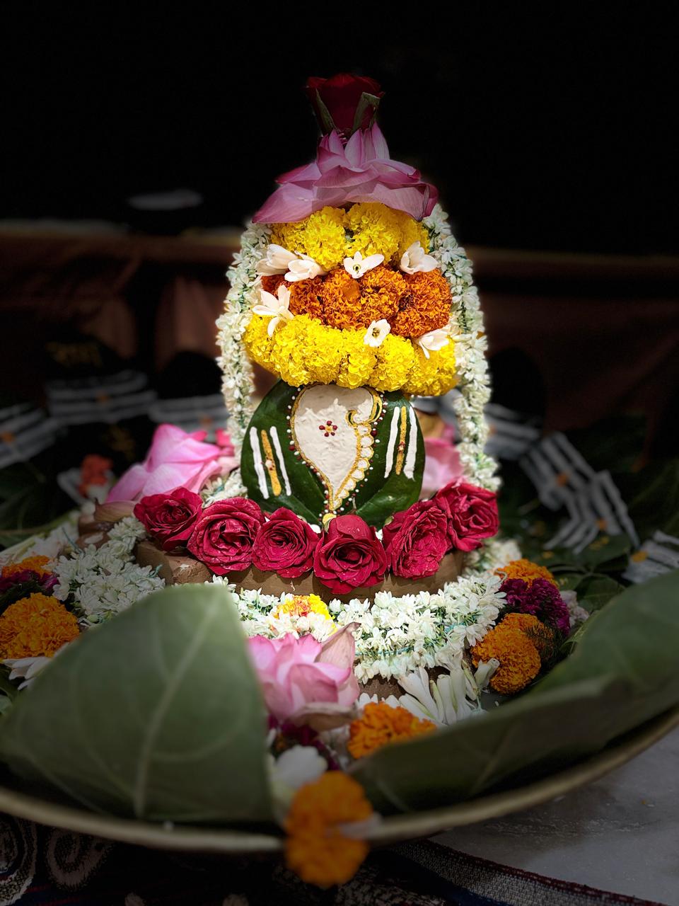 Flower-adorned sacred form arranged for worship.