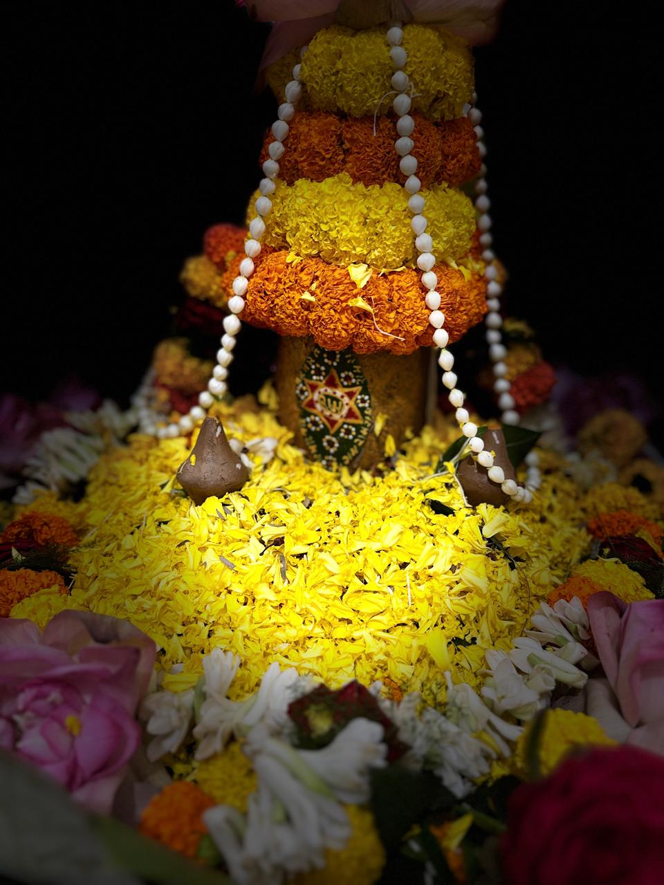 Floral and sacred-leaf adornment during the observance.