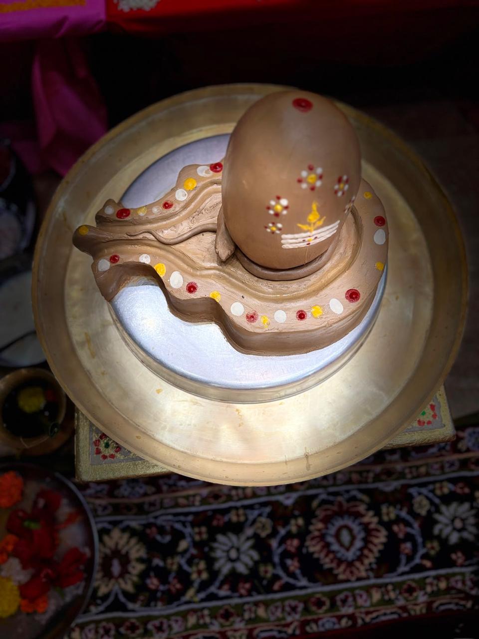 Decorated earthen Shiva lingam viewed from above.