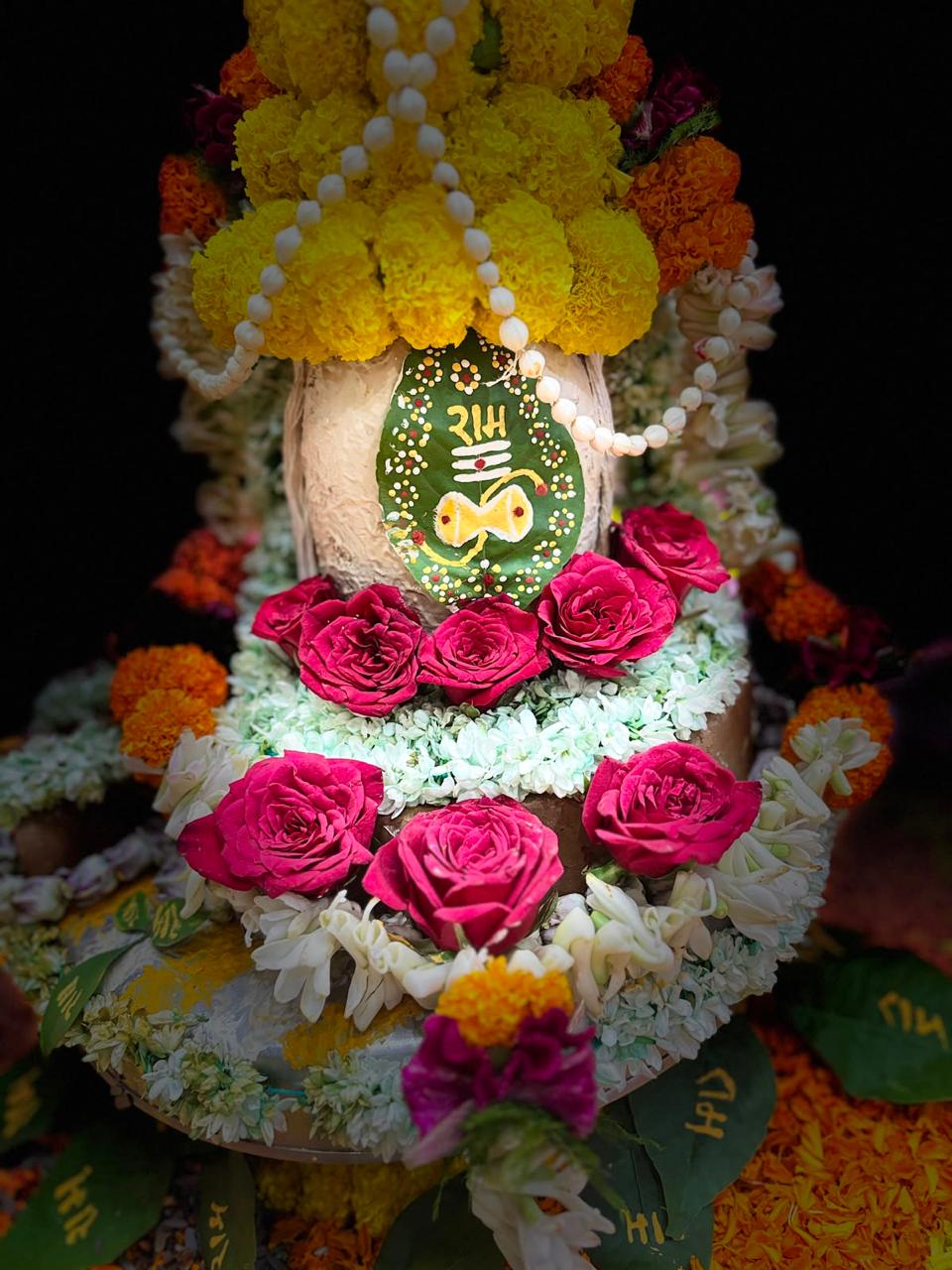 Floral adornment with roses, marigolds and sacred leaves.