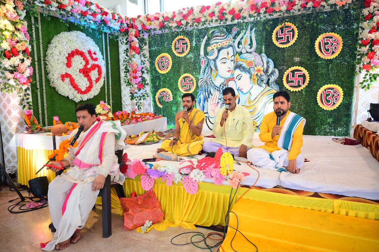 Vedic ceremony framed by Shiva-Parvati imagery.